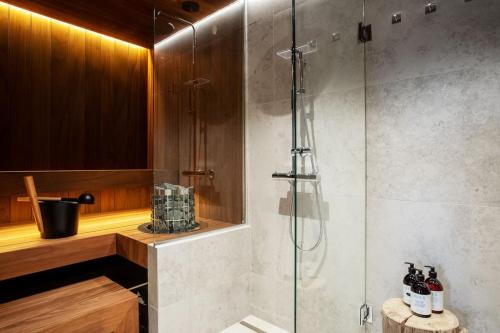 a bathroom with a shower with a glass door at Stay North - Joiku - Voice of Lapland in Äkäslompolo