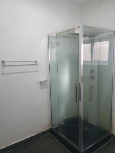 a shower stall with a glass door in a bathroom at HAVRE DE CHARME A YAOUNDE in Yaoundé