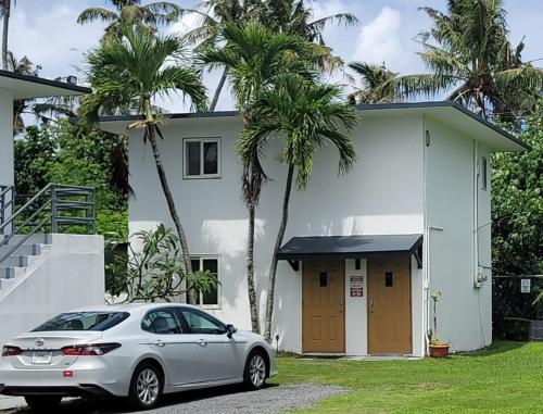a car parked in front of a house with palm trees at Ocean Villa Guam in Tamuning