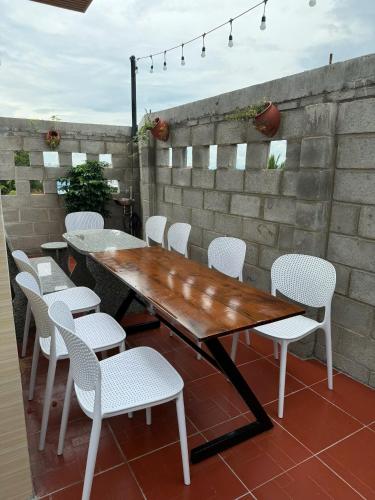a wooden table and white chairs on a patio at Sea-Breeze Homestay in Phan Thiet
