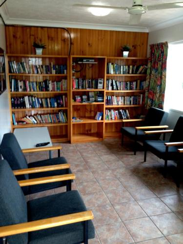 a library with couches and book shelves filled with books at Coral Coast Tourist Park in Townsville