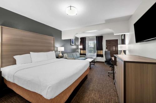 a hotel room with a large bed and a television at Quality Inn & Suites Fayetteville I-95 in Fayetteville
