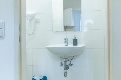 a white bathroom with a sink and a mirror at Elegant 2BR Apt.@Wiener Stadthalle/Central Located in Vienna