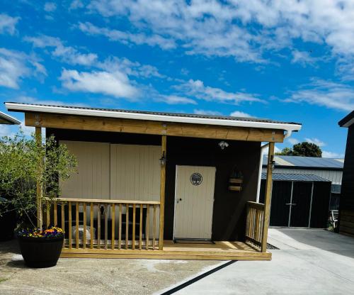 a shed with a porch and a door at The Olive Tree Shed in Whakatane