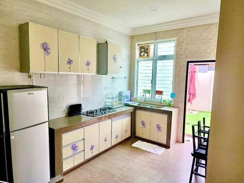 a kitchen with green and white cabinets and a refrigerator at Kuantan Setali ROOMSTAY by Iconique in Kuantan