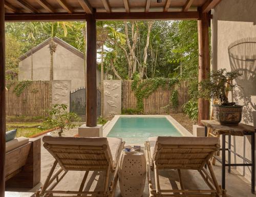a swimming pool with two chairs and a table at aNhill Boutique in Hue