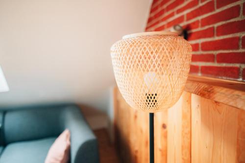 a lamp in a living room next to a brick wall at Podklášterský domek in Třebíč