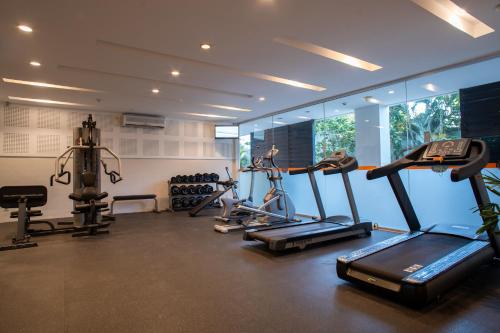 a gym with several tread machines in a room at HARRIS Hotel & Residences Riverview Kuta, Bali in Kuta