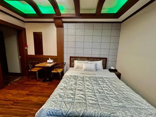 a bedroom with a bed with a green ceiling at Dreamhill motel in Gyeongju