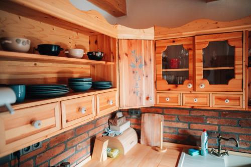 a kitchen with wooden cabinets and a sink at Podklášterský domek in Třebíč