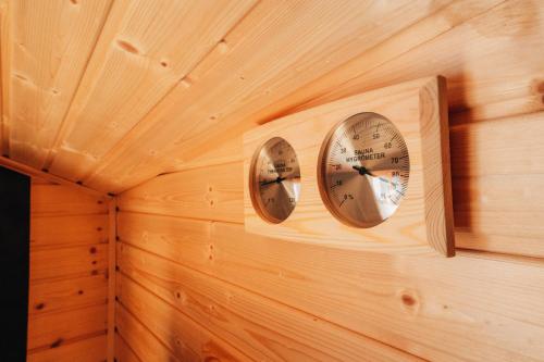 two clocks on a wall in a wooden room at Podklášterský domek in Třebíč