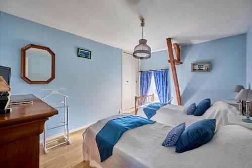 una camera da letto con pareti blu e un letto con cuscini blu di La Ferme de la Chapelle Saint-Roch - Maison de 190 m2 a Isigny-sur-Mer