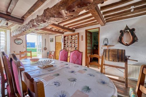 une salle à manger avec une table et quelques chaises dans l'établissement La Ferme de la Chapelle Saint-Roch - Maison de 190 m2, à Isigny-sur-Mer