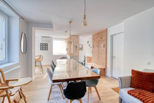 une salle à manger et un salon avec une table et des chaises dans l'établissement La Grande Cordée - Appt au pied des Pyrénées, à Ax-les-Thermes
