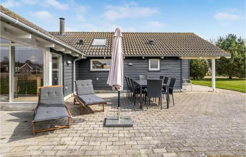 a patio with a table and chairs and an umbrella at Holiday Home Blommestien V Denmk in Marielyst