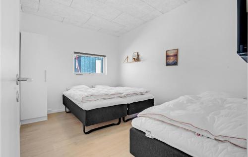 two beds in a room with white walls and wooden floors at Amazing Home In Børkop With Wifi in Børkop