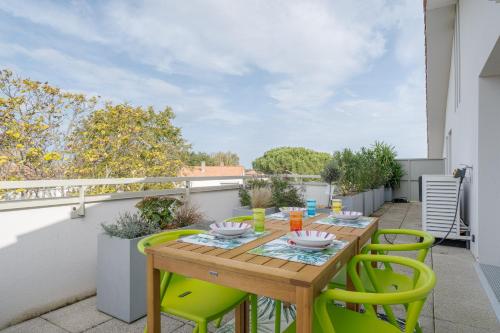 d'une terrasse avec une table et des chaises en bois sur un balcon. dans l'établissement Le Van Gogh - Bel appt pour 5 à Blagnac, à Blagnac
