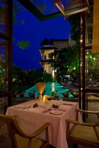 a table in a restaurant with a view of a pool at aNhill Boutique in Hue