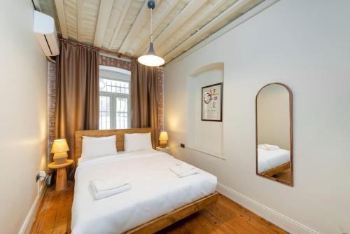a bedroom with a white bed and a mirror at Maison Chic - Newly Renovated 3Br in City Center in Istanbul