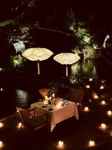 a dinner table with two umbrellas and lights at aNhill Boutique in Hue