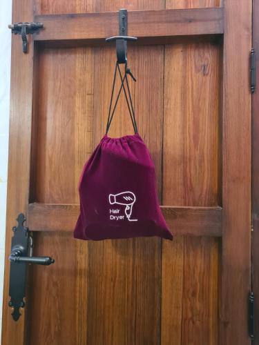 a purple bag hanging on a wooden door at La Posada Amena in Carcabuey