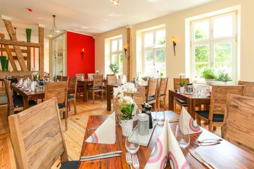 uma sala de jantar com mesas e cadeiras de madeira em Restaurant & Pension Eshramo em Barth