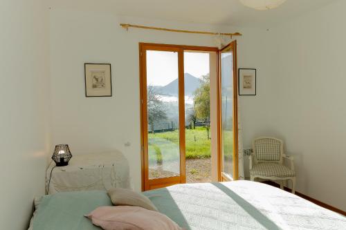 a bedroom with a bed and a sliding glass door at Superbe Maison Pour 6 Personnes in Saint-Jean-dʼArvey