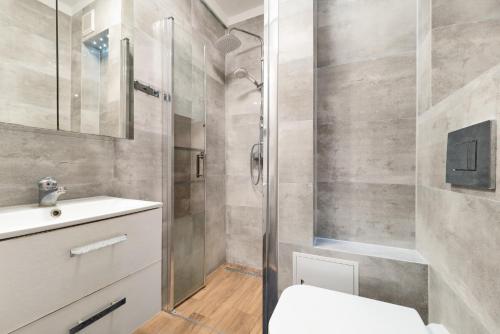 a bathroom with a shower and a toilet and a sink at Simple Nook, Gdańsk Wejhera by Real Apartments in Gdańsk