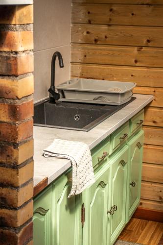 a kitchen with green cabinets and a sink at Le Palmi Chalet charmant in La Plaine des Palmistes