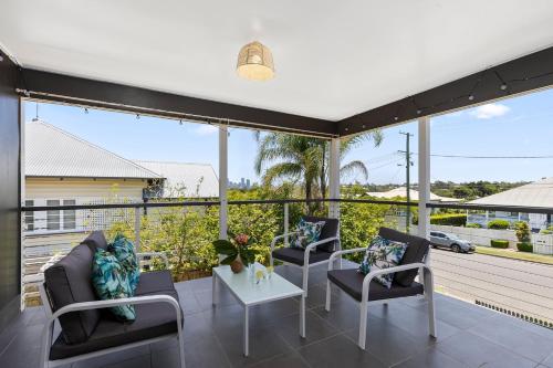 a patio with chairs and a table on a balcony at Wow Bridge views Near CBD Quiet bus train in Brisbane