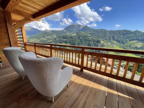 two chairs on a deck with a view of mountains at CHALET LA MANIGODINE Piscine 18-24 pers in Manigod
