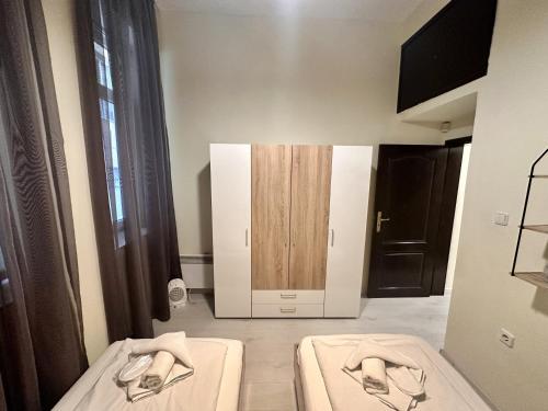 a room with two beds and a wooden cabinet at Prime Stays at 34 Bratya Miladinovi Street in Sofia