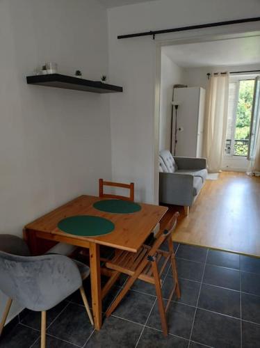 Cette chambre comprend une table et des chaises en bois. dans l'établissement Beau studio dans une rue calme, à Boulogne-Billancourt