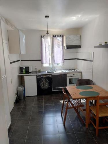 une cuisine avec une table et une cuisine avec une cuisinière dans l'établissement Beau studio dans une rue calme, à Boulogne-Billancourt