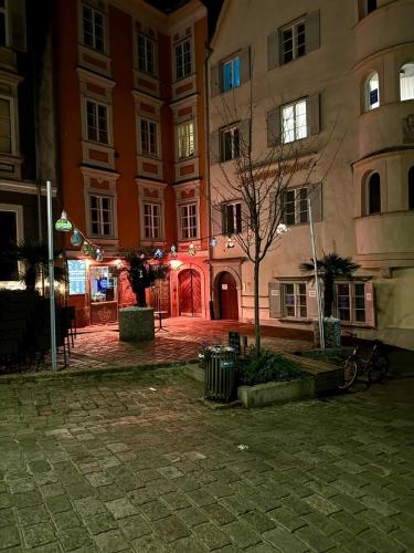a large building with lights in a courtyard at night at Goldene Pastete - Urban Luxury Apartments City Center in Graz