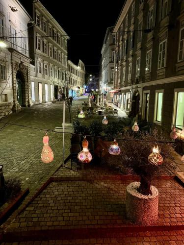 a city street at night with lit up vases at Goldene Pastete - Urban Luxury Apartments City Center in Graz