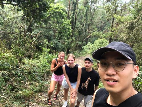 a group of people walking on a trail in the woods at Noi Bai Flight Path Homestay in Hanoi