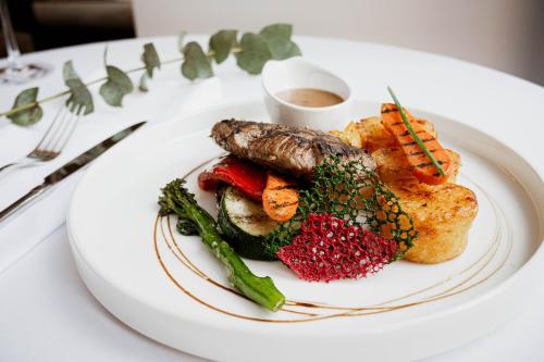 a white plate of food on a table at VICTORIA Hotel Kaunas in Kaunas
