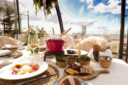 a table with food and a view of a city at BLESS Hotel Madrid - The Leading Hotels of the World in Madrid