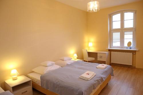 um quarto com 2 camas, uma secretária e uma janela em Apartamenty w sercu Chełmna em Chełmno