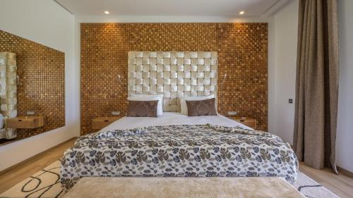 a bedroom with a large bed and a brick wall at Villa Maria, Luxury Marrakech in Marrakesh