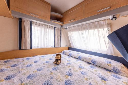 a teddy bear sitting on a bed in a bedroom at Camping Village Le Calanchiole in Capoliveri