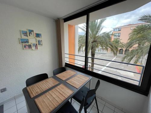 une table et des chaises dans une pièce avec une fenêtre dans l'établissement Appartement 2 pièces 4 couchages ARGELES SUR MER AR370-013, à Argelès-sur-Mer