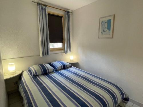 - une chambre avec un lit, une fenêtre et deux lampes dans l'établissement Appartement 2 pièces 4 couchages ARGELES SUR MER AR370-013, à Argelès-sur-Mer