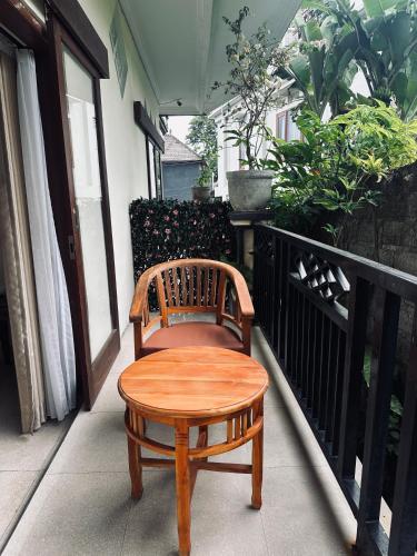 a wooden chair sitting on a balcony at Puri Jumpungan Villas in Sidemen