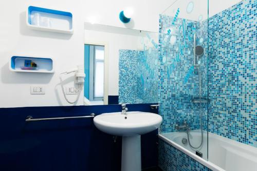 a blue and white bathroom with a sink and a shower at Correra 241 Lifestyle Hotel in Naples