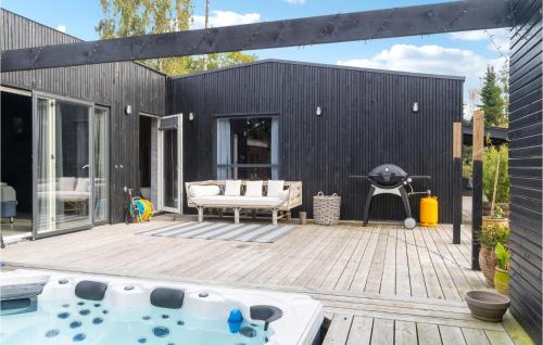 a patio with a hot tub and a grill at Awesome Home In Væggerløse With Kitchen in Marielyst