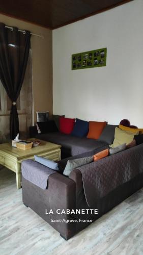 a living room with a couch and a table at La Cabanette in Saint-Agrève