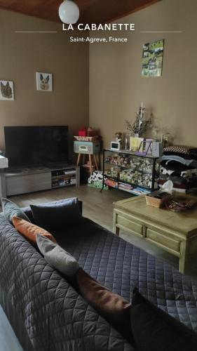 a living room with a bed and a table at La Cabanette in Saint-Agrève
