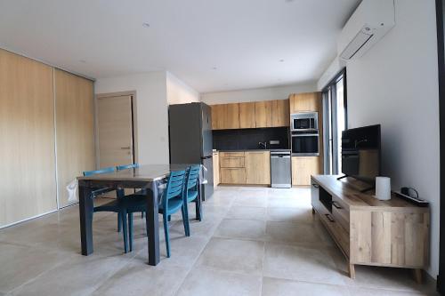 - une cuisine avec une table et des chaises bleues dans la chambre dans l'établissement T2 Azur - Plage & commerces à 200m- Barbecue - Parking - Wifi, à Albitreccia